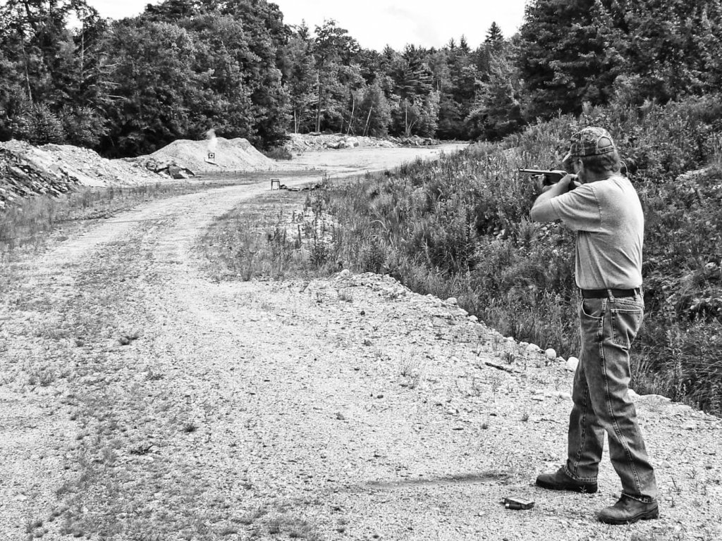 Man firing shotgun while standing