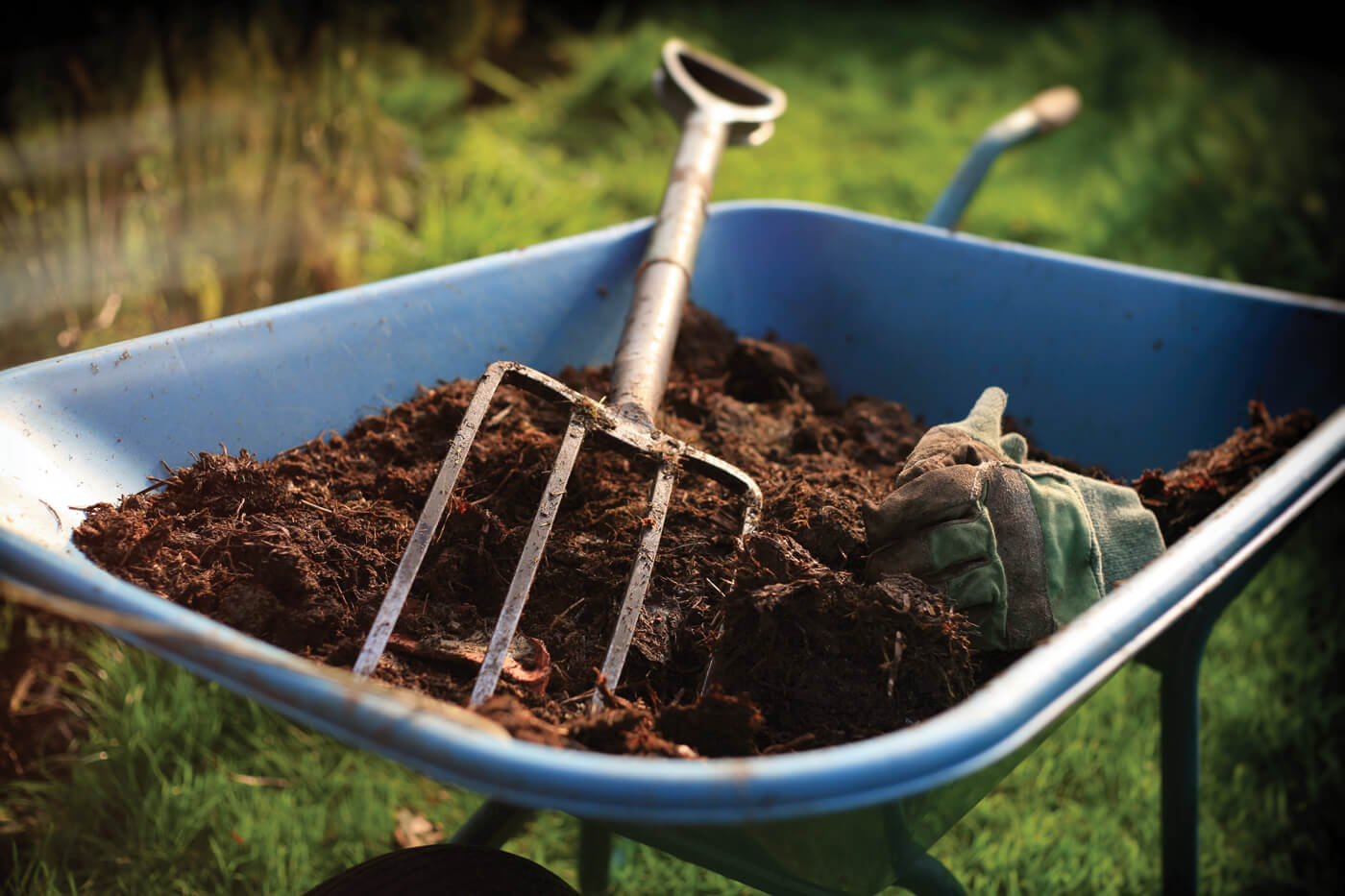 Pitchfork on wheelbarrow with soil and compost