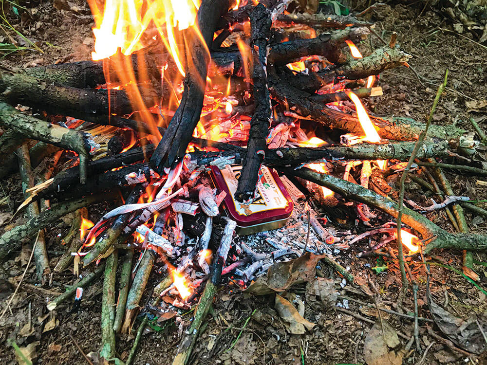 Natural materials, such as some cotton gun-cleaning patches, can be turned into charred tinder by cooking them in the fire. 