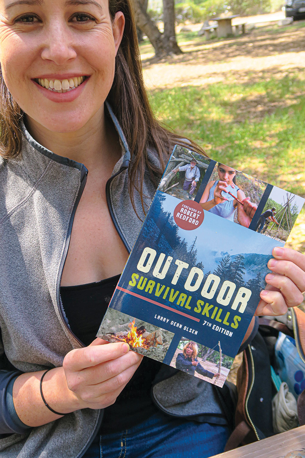Survival skills practitioner Diann Benti with a copy of the seventh edition of Olsen’s classic Outdoor Survival Skills