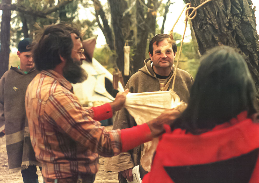 Olsen (center) watches John McPherson processing an animal hide in 1988 at a Rabbit Stick Rendezvous. 
