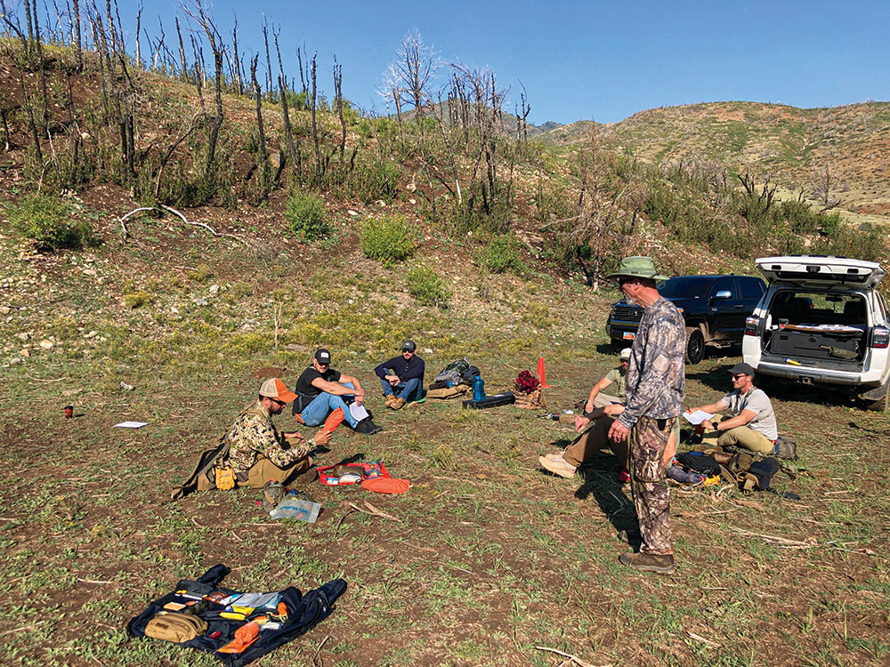 Gear checks and discussions take place before a Fieldcraft Survival class begins in Utah.