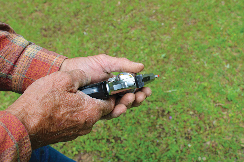 Use your thumb to close the cylinder, rotating the gun into a two-handed grip.