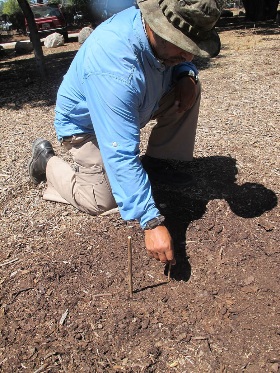 Angelo Cervera has placed a stick in the ground. He is now marking the tip of the stick’s shadow.