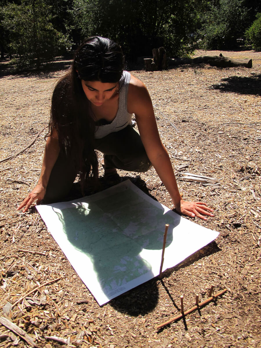 Monica Montoya adjusts her map to true north by using the sun.