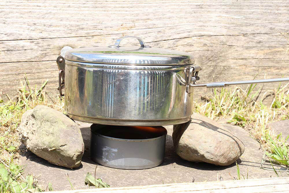 Rocks or logs can be used in conjunction with the alcohol stove.