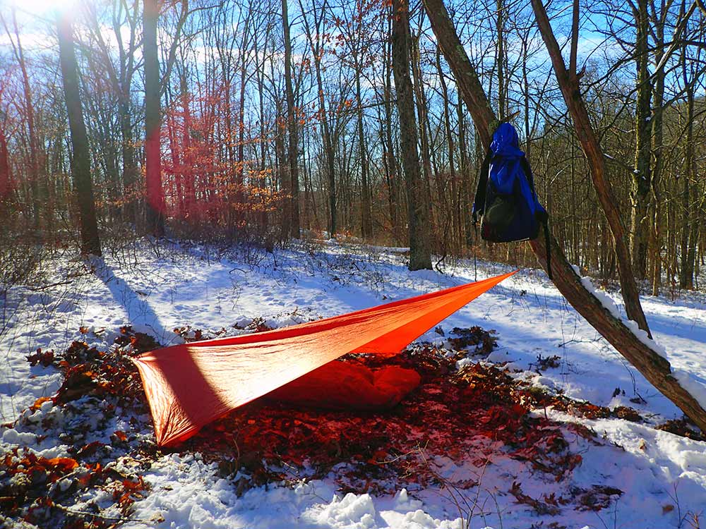 A simple tarp setup is all the author uses in a plow point or lean-to configuration. This Coalcracker Bushcraft T6ZERO tarp weighs 5.7 ounces and comes with 2 tie-outs attached.