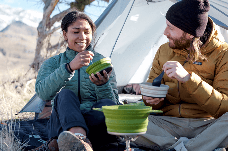 Two people use camp cook set