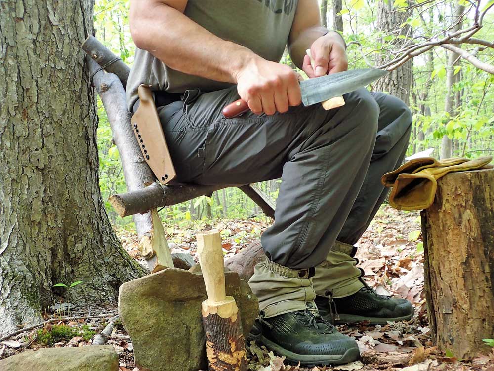 The author uses the completed Roycroft-style chair/stool against a tree. 